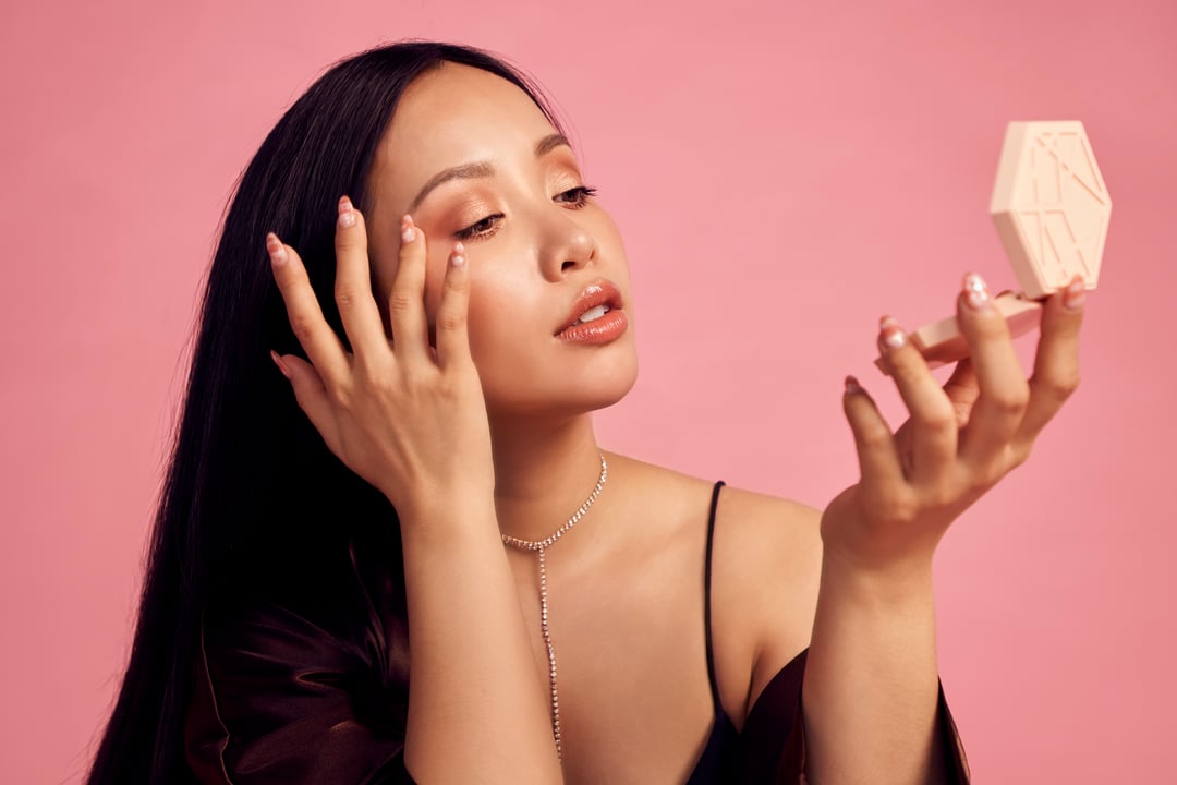 EM Cosmetics founder Michelle Phan applies blush.