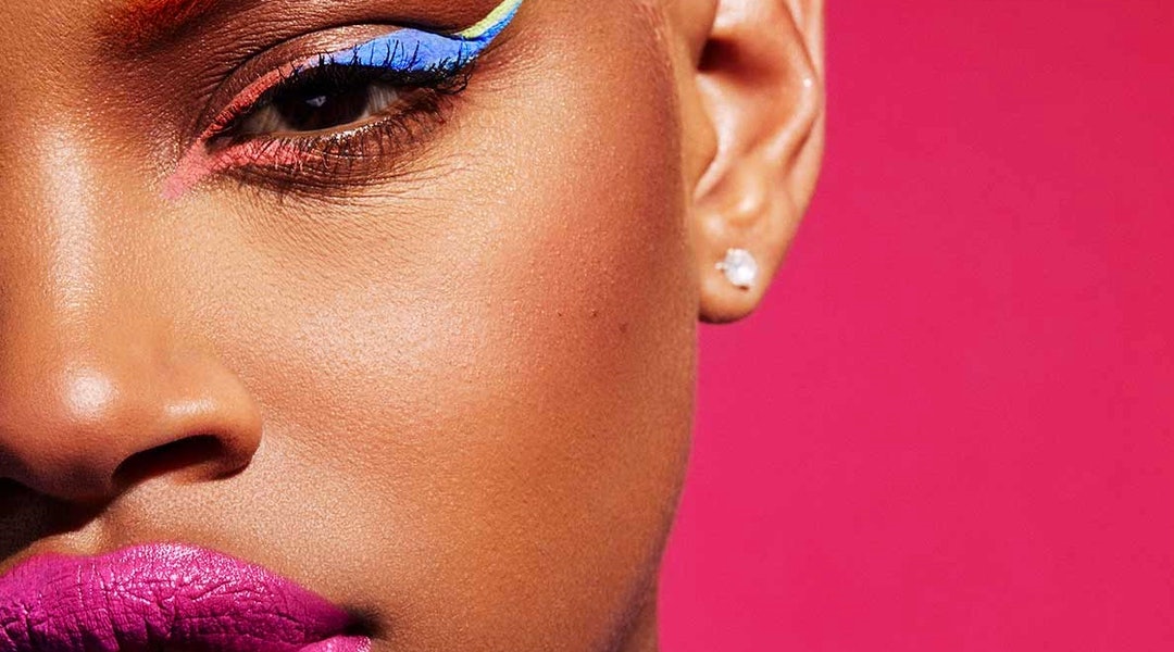 A model shows off a colorful makeup look created with Fenty Beauty products. 