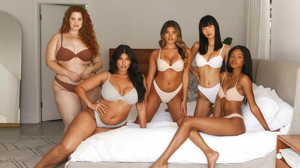 An advertisement for top lingerie brand Lounge Underwear, featuring five female models on a bed. 