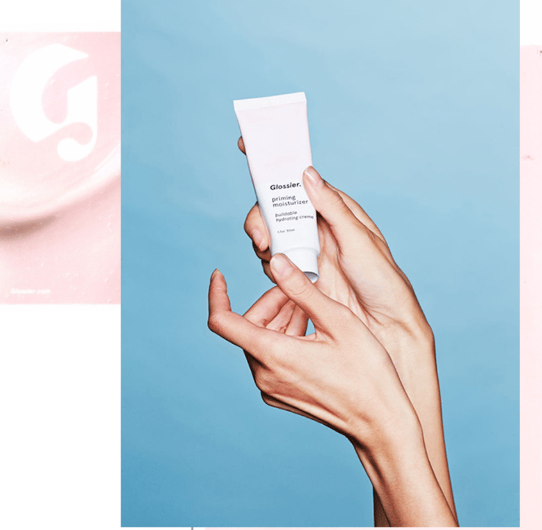 A Glossier advertisement for its Priming Moisturizer, featuring the brand’s logo and its signature pink shade.