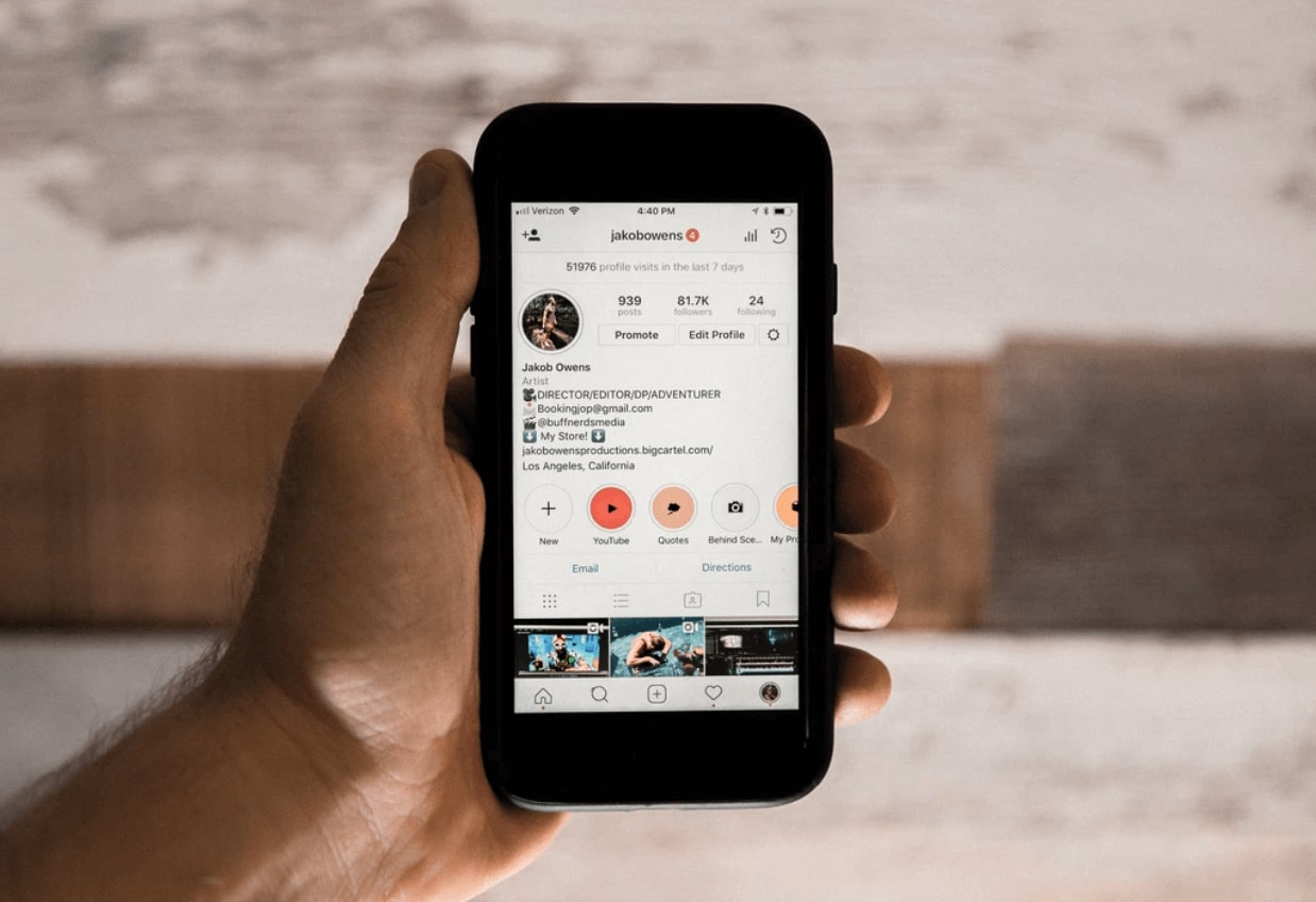 A hand holding a phone showing an Instagram profile. Jakob Owens via Unsplash.