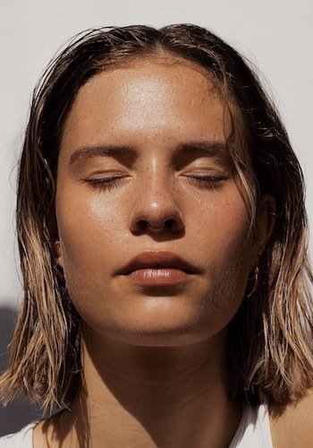 A portrait of a millennial woman with clear, clean skin, by Fleur Kaan.