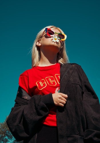 A gen z fashion influencer wearing colorful sunglasses, by Katsiaryna Endruszkeiwicz.
