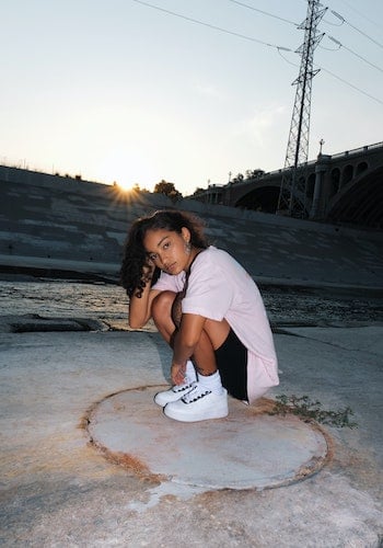 A gen z influencer wearing white sneakers, by Mike Von.