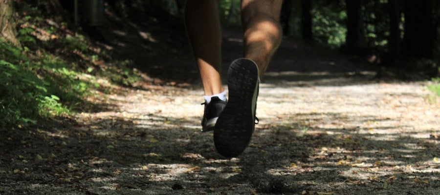 A close-up of a trail runner’s legs and shoes, by Tara Glaser. 