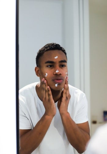 A Gen Z influencer applies skincare products in a mirror, by The Creative Exchange. 