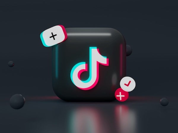 A 3D graphic of the TikTok app icon along with plus sign and checkmark icons, by Mariia Shalabaieva via Unsplash.