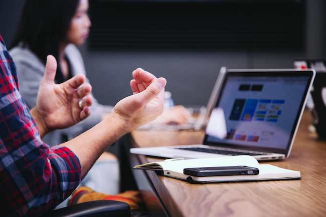 A person explains marketing findings in front of a laptop