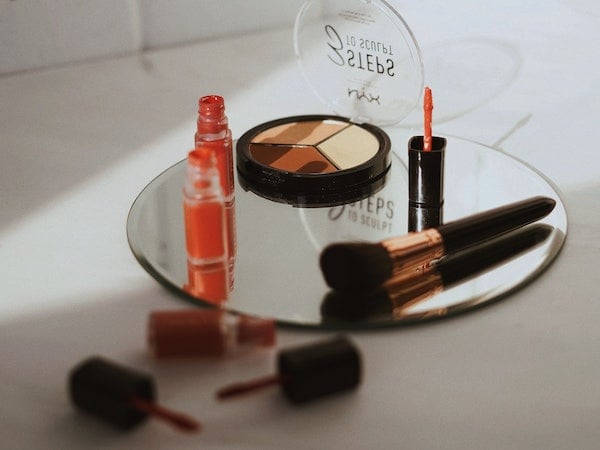 A variety of Gen Z makeup products arranged on top of a mirror, by Olena Sergienko via Unsplash.