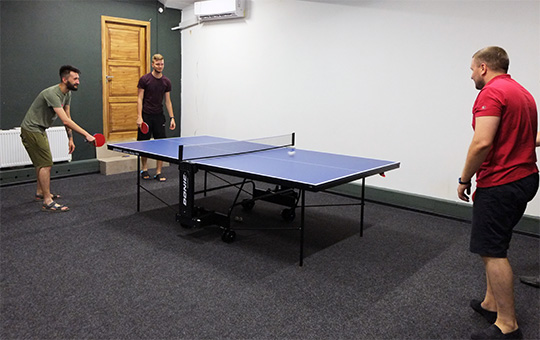 Three guys playing ping pong