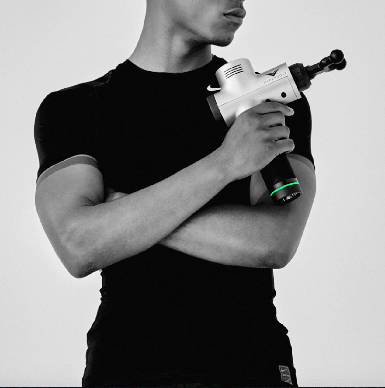 An athlete poses with a Hyperice device.