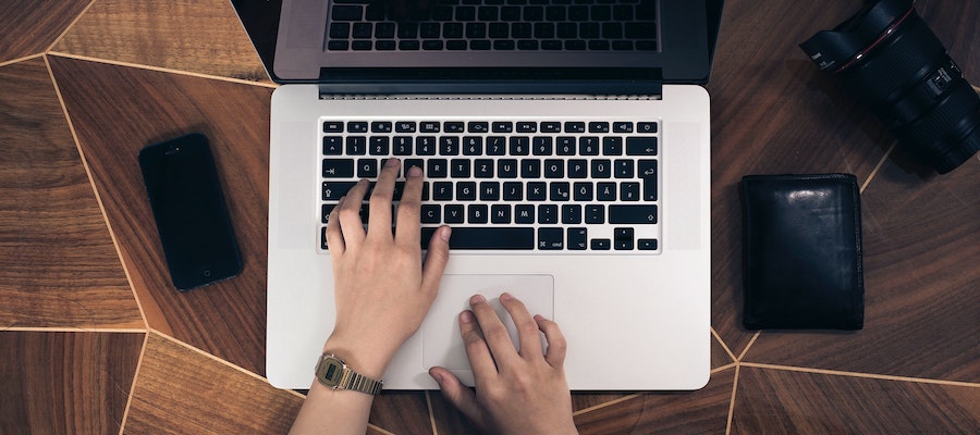 The hands of an influencer marketing manager typing on a laptop keyboard, by Fabian Israra.