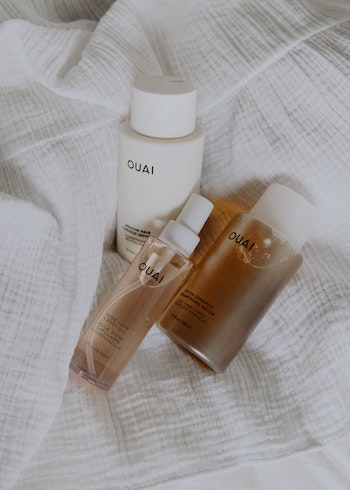 Three Ouai products on a white linen sheet, by Mathilde Langevin. 