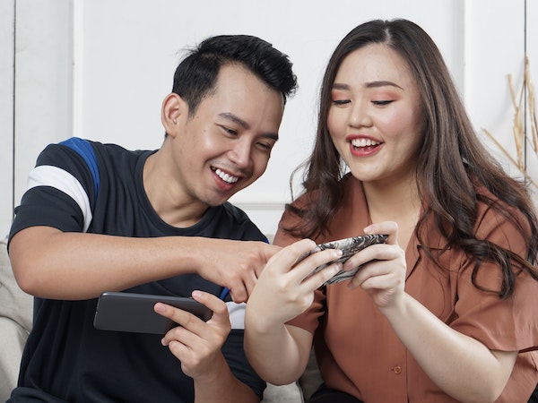 A man and woman shopping for product on TikTok, by Afif Kusama via Unsplash.