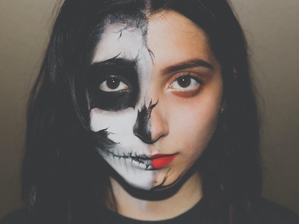 A Gen Z TikTok creator with half of her face painted like a skull for Halloween, by Edgar Perez via Unsplash.