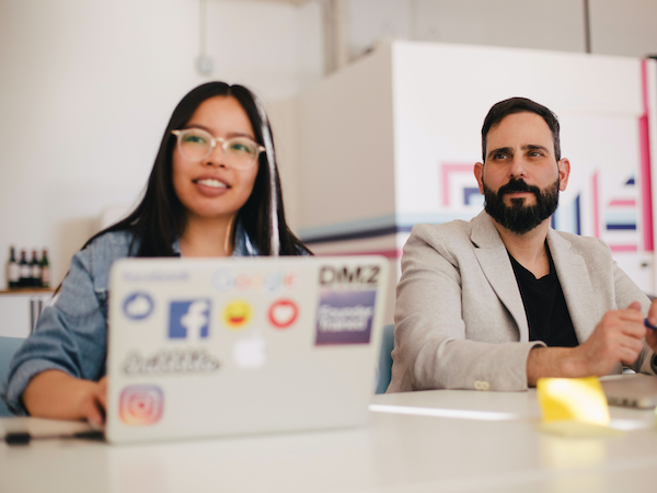 a young woman and a man viewing the best influencer marketing platform on a laptop with stickers