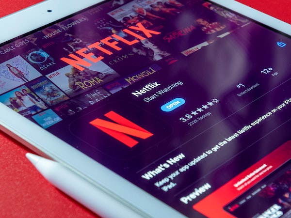 A close-up photo of an iPad displaying Netflix, a media brand that excels at influencer marketing, by Souvik Banerjee via Unsplash.
