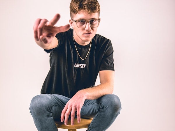 a TikTok creator on a stool making the peace sign, by Patrick T. Kindt via Unsplash